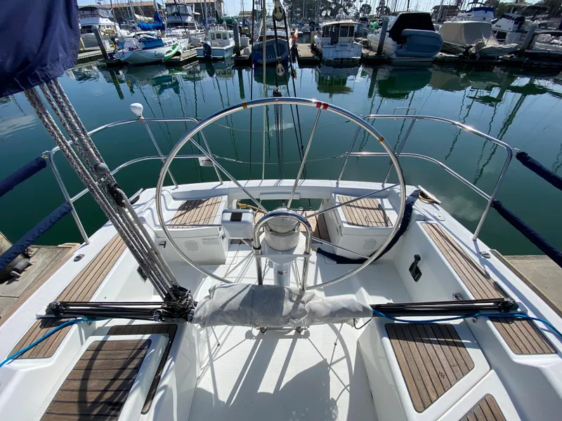2004 Beneteau 36.7 sailboat cockpit with steering wheel, docked at marina.
