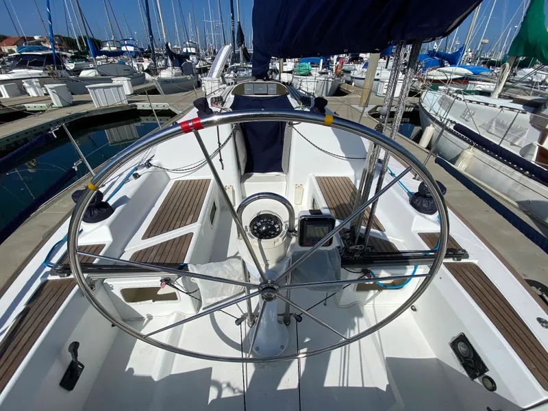 2004 Beneteau 36.7 sailboat cockpit with steering wheel at marina.