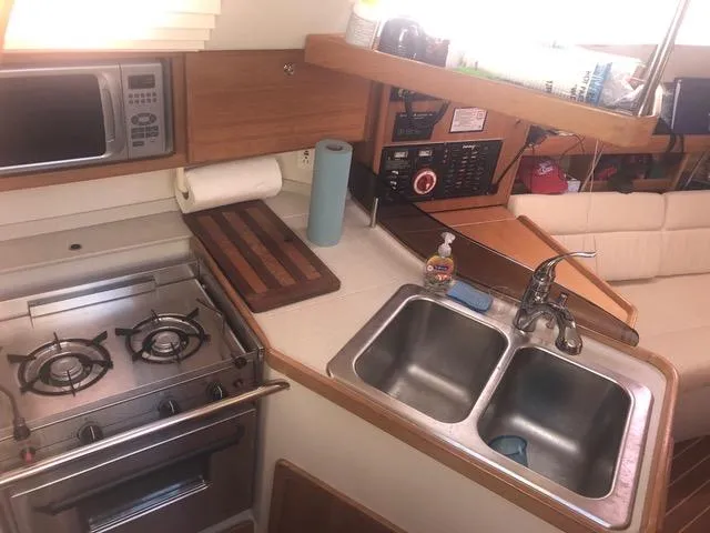 Galley kitchen in 2008 Catalina 320 MkII sailboat with stove, sink, and microwave.