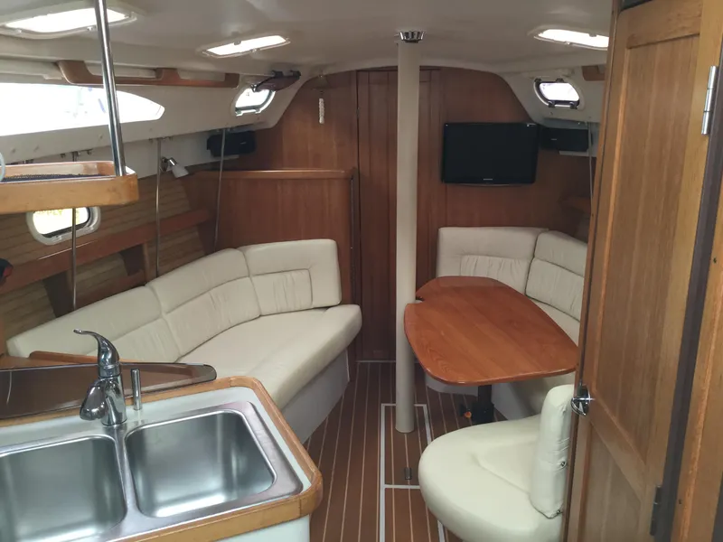Interior of 2008 Catalina 320 MkII sailboat with wood finish and cozy seating area.