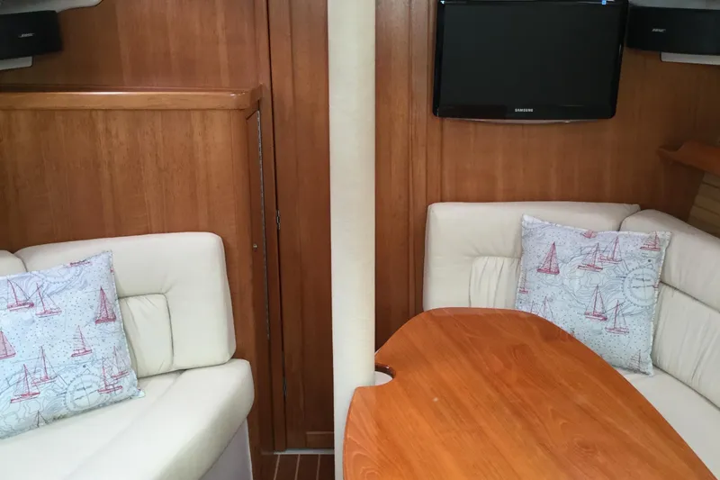 Interior of 2008 Catalina 320 MkII sailboat with cozy seating and wooden table.