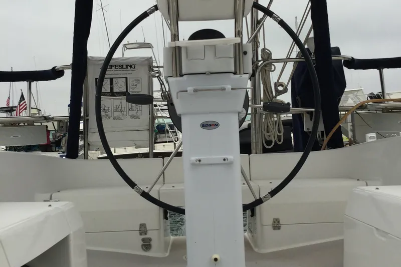 Cockpit view of a 2008 Catalina 320 MkII sailboat with steering wheel and navigation equipment.