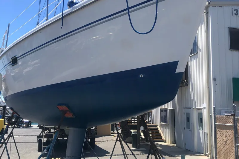 2008 Catalina 320 MkII sailboat on dry dock, blue and white hull, marina setting.