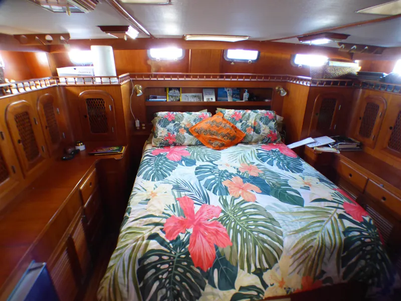 Cozy cabin interior of 1984 Spindrift 39 ft yacht with floral bedding and wooden furnishings.