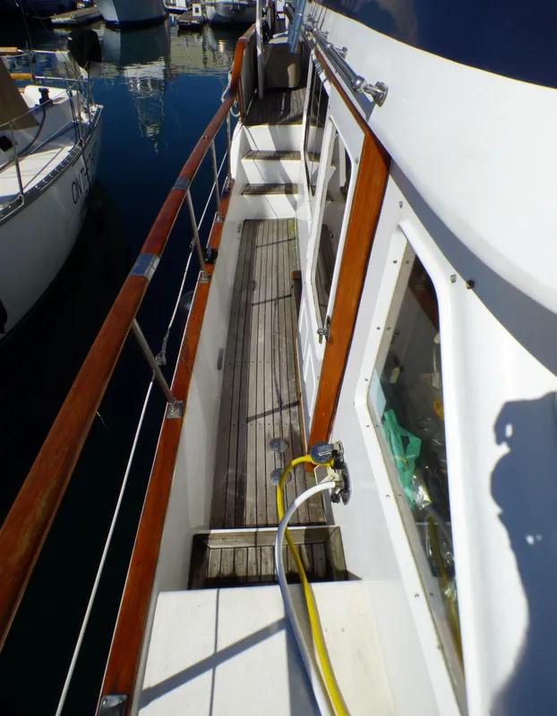 1984 Spindrift 39 ft. Aft Cabin Twin Diesel yacht deck with wooden railings and docked boats.
