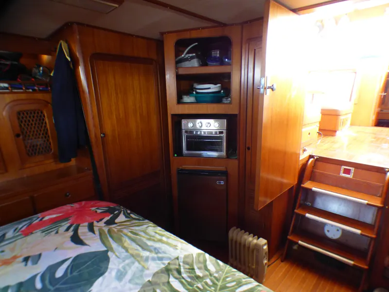 1984 Spindrift 39 ft. aft cabin interior with wood paneling and floral bedding.