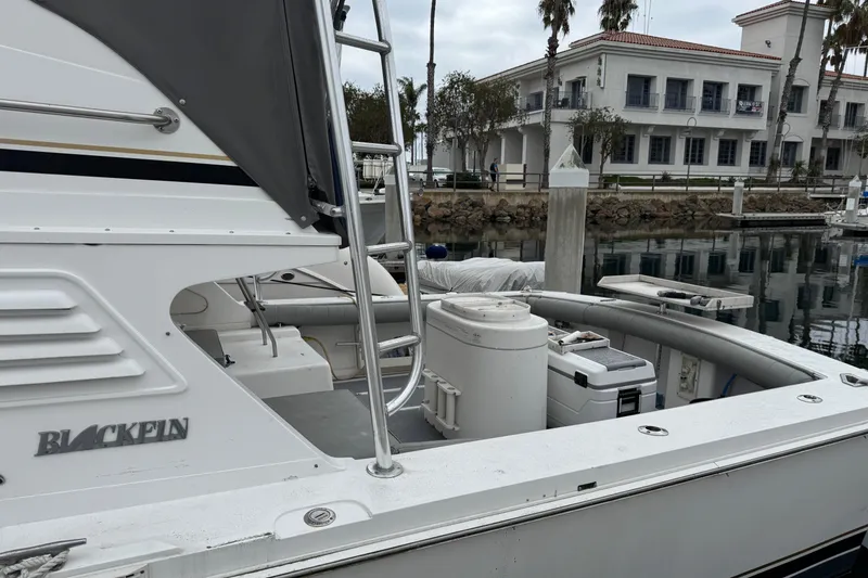 1993 Blackfin Sportfisher boat docked at marina with buildings in background.