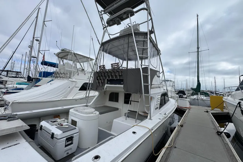 1993 Blackfin Sportfisher boat docked at marina, surrounded by other vessels under cloudy skies.