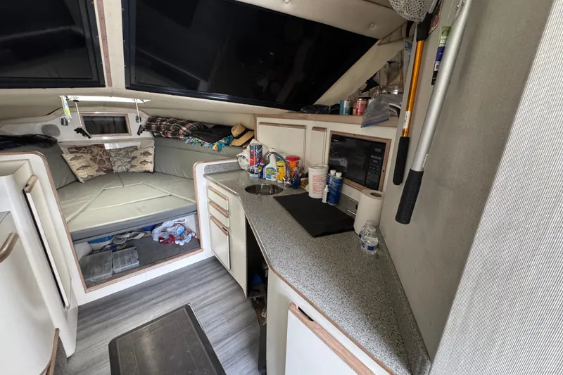 Interior of a 1993 Blackfin Sportfisher boat with kitchenette and cozy sleeping area.