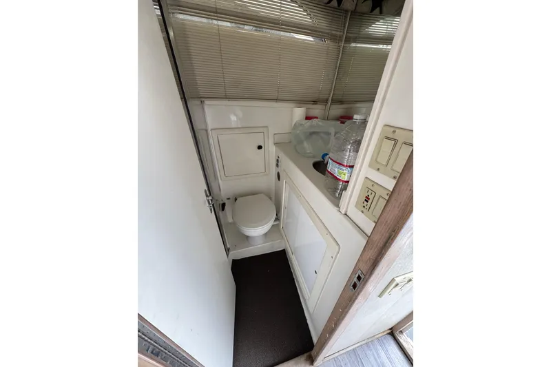 1993 Blackfin Sportfisher boat bathroom with toilet, sink, and storage cabinets.