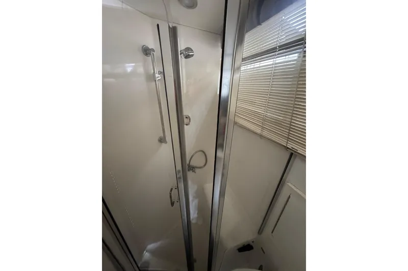 Shower area in 1993 Blackfin Sportfisher boat with glass door and blinds.