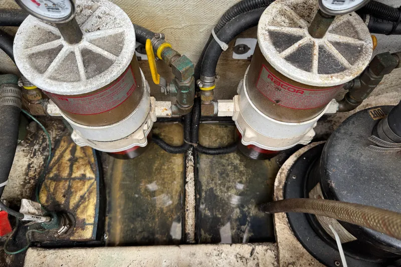 Engine room of a 1993 Blackfin Sportfisher with dual fuel filters and hoses.