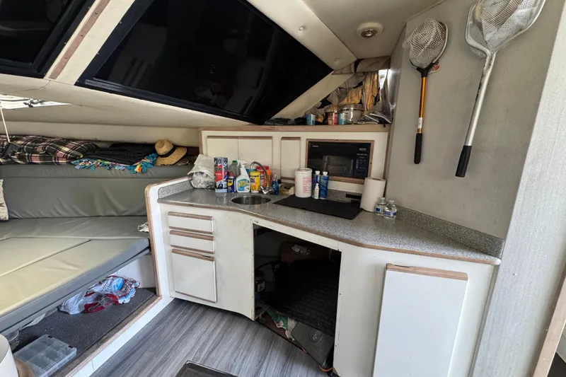 1993 Blackfin Sportfisher interior with kitchenette, fishing nets, and seating area.