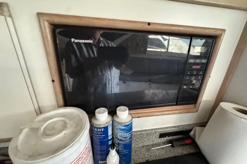 Panasonic microwave in 1993 Blackfin Sportfisher kitchen with cleaning supplies.