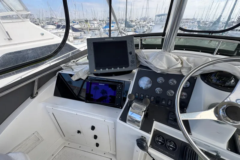 1993 Blackfin Sportfisher helm with navigation equipment and marina view.