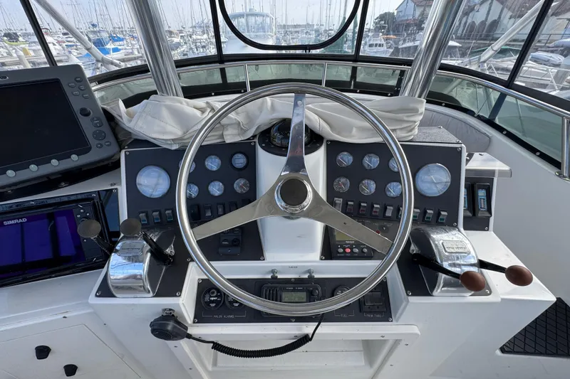 1993 Blackfin Sportfisher helm with steering wheel, gauges, and navigation equipment.