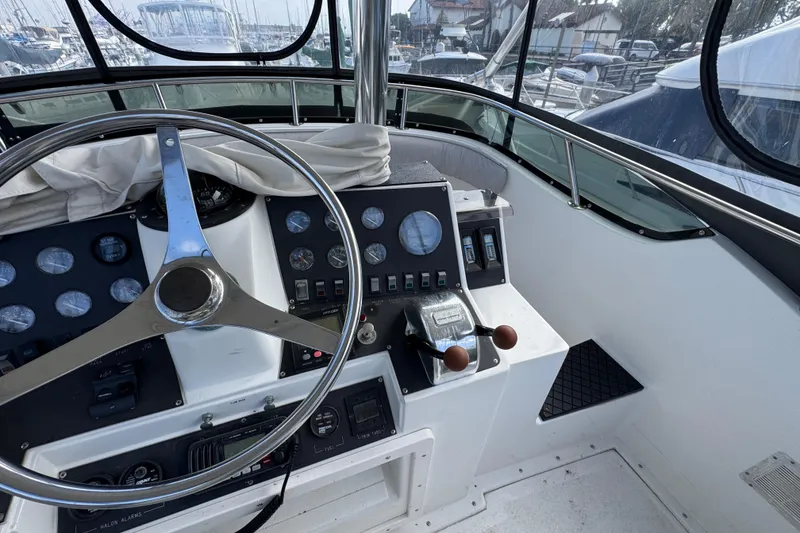 1993 Blackfin Sportfisher helm with steering wheel and control panel, docked at marina.