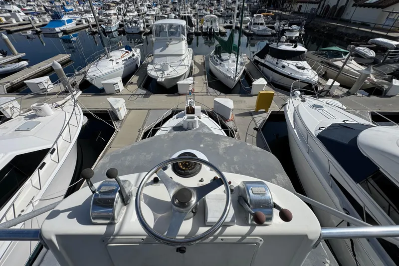 1993 Blackfin Sportfisher boat helm overlooking marina with numerous docked boats.
