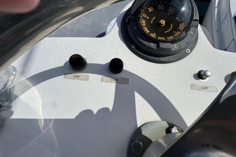 1993 Blackfin Sportfisher dashboard with compass, start, and stop buttons.