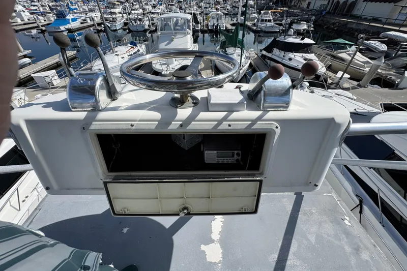 1993 Blackfin Sportfisher helm with steering wheel, controls, and marina view.
