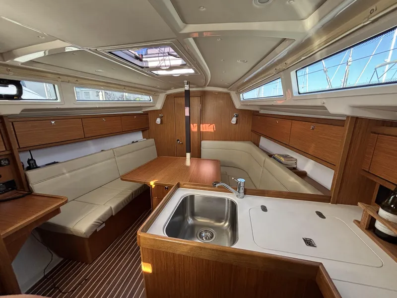 Interior of 2020 Bavaria Cruiser 34 yacht with modern wood finish and compact kitchen.