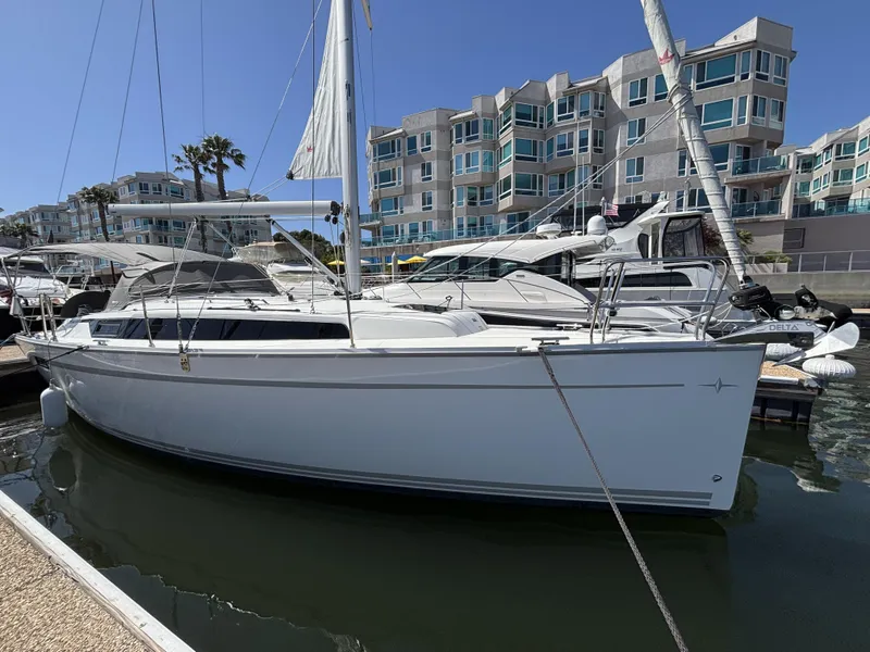 2020 Bavaria Cruiser 34 sailboat docked in marina, modern buildings in background.