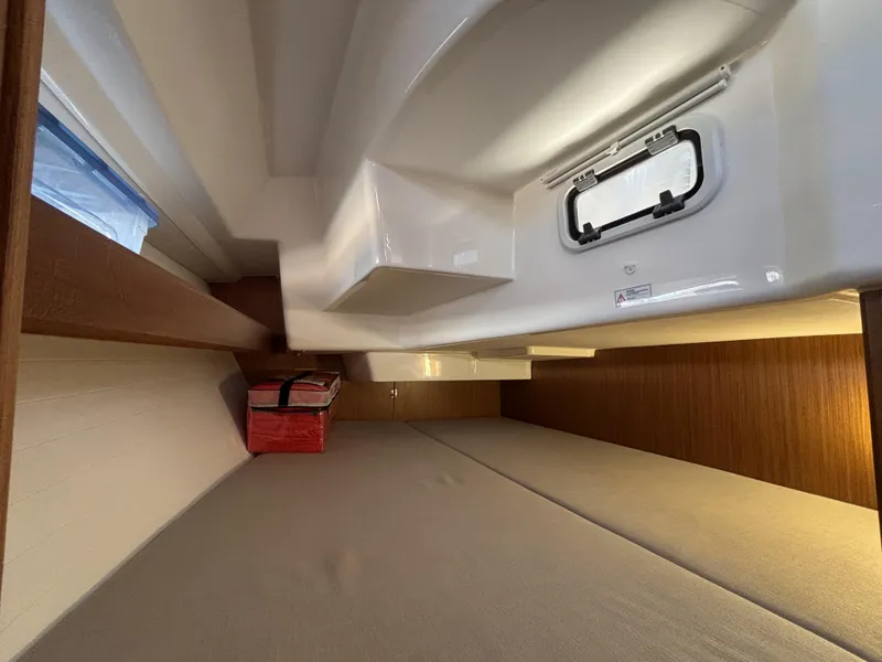 Interior cabin of 2020 Bavaria Cruiser 34 yacht with wooden accents and a small window.