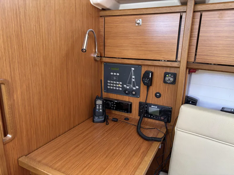 Navigation station of 2020 Bavaria Cruiser 34 yacht with communication equipment and wooden cabinetry.