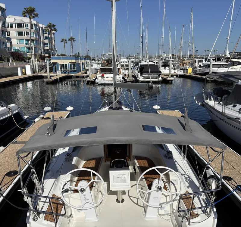 2020 Bavaria Cruiser 34 yacht docked in a sunny marina, surrounded by sailboats.