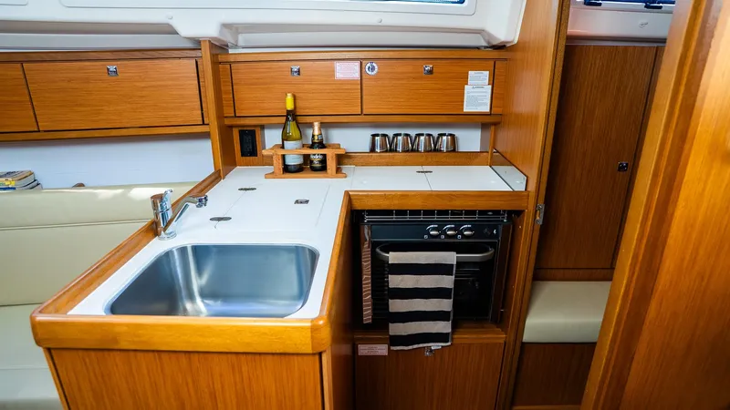 2020 Bavaria Cruiser 34 yacht kitchen with wooden cabinetry and modern appliances.