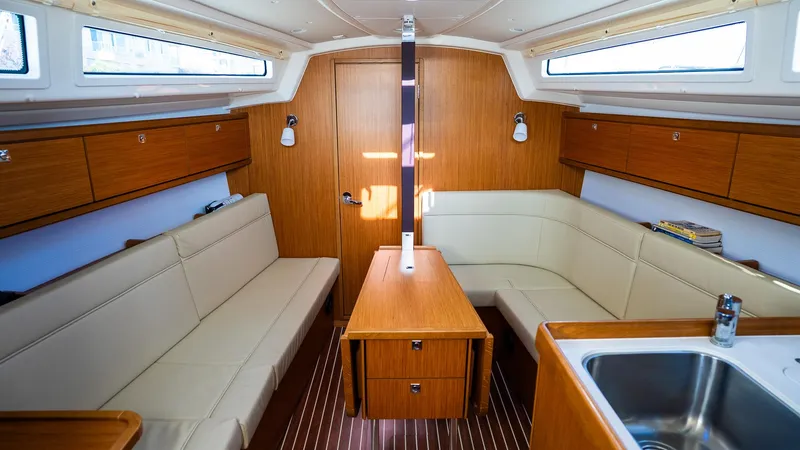 Interior of 2020 Bavaria Cruiser 34 yacht with wooden furnishings and beige seating.