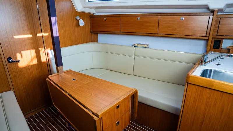 Interior of 2020 Bavaria Cruiser 34 yacht with wooden cabinetry and beige seating.