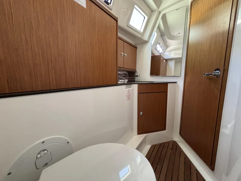 2020 Bavaria Cruiser 34 yacht bathroom with wooden cabinets and flooring.
