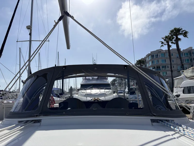 2020 Bavaria Cruiser 34 sailboat docked in a sunny marina with palm trees.