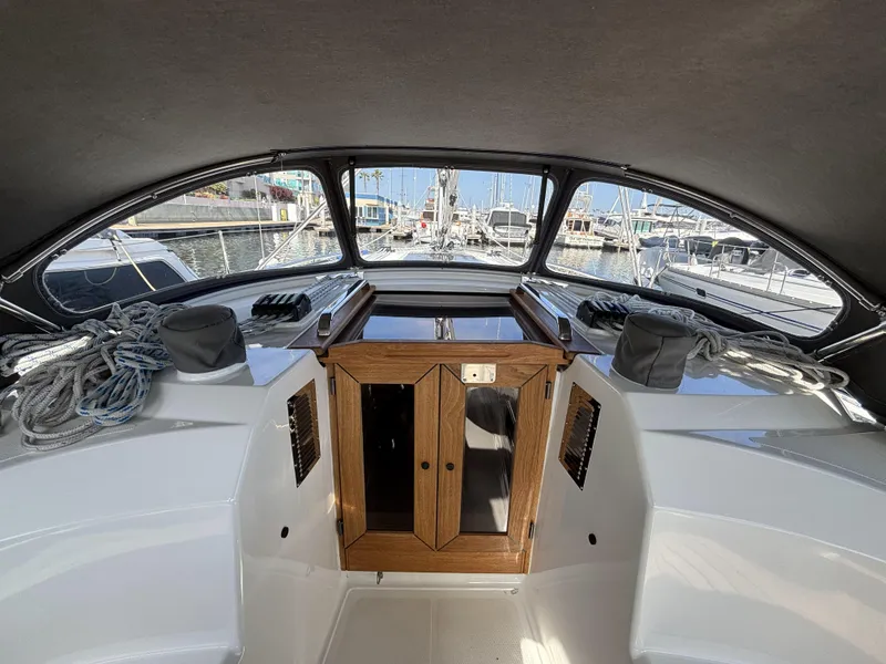 2020 Bavaria Cruiser 34 yacht cockpit with ropes and wooden hatch, docked at marina.