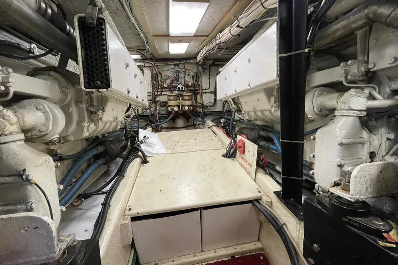 Engine room of a 1975 Uniflite Sport Fisher 42, showcasing dual engines and mechanical components.