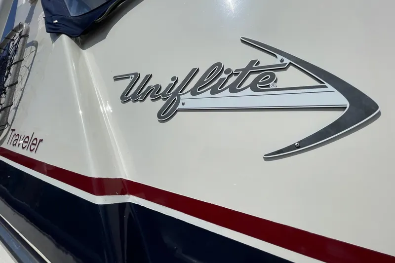 1975 Uniflite Sport Fisher 42 boat with logo and red-blue stripe design.