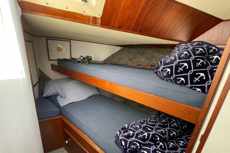 1975 Uniflite Sport Fisher 42 cabin with cozy bunk beds and nautical-themed decor.