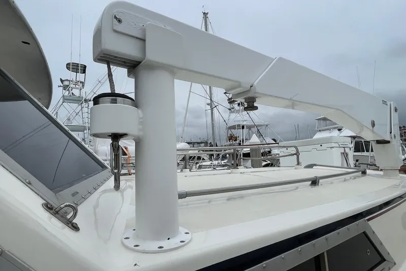 1975 Uniflite Sport Fisher 42 boat deck with crane, marina background.