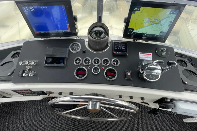 Cockpit of 1975 Uniflite Sport Fisher 42 with navigation screens and controls.