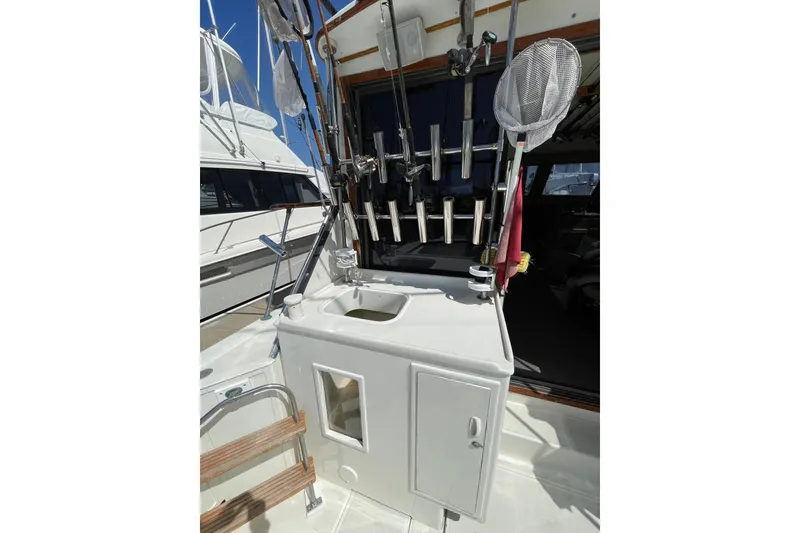 1975 Uniflite Sport Fisher 42 fishing gear setup with rods and net on deck.