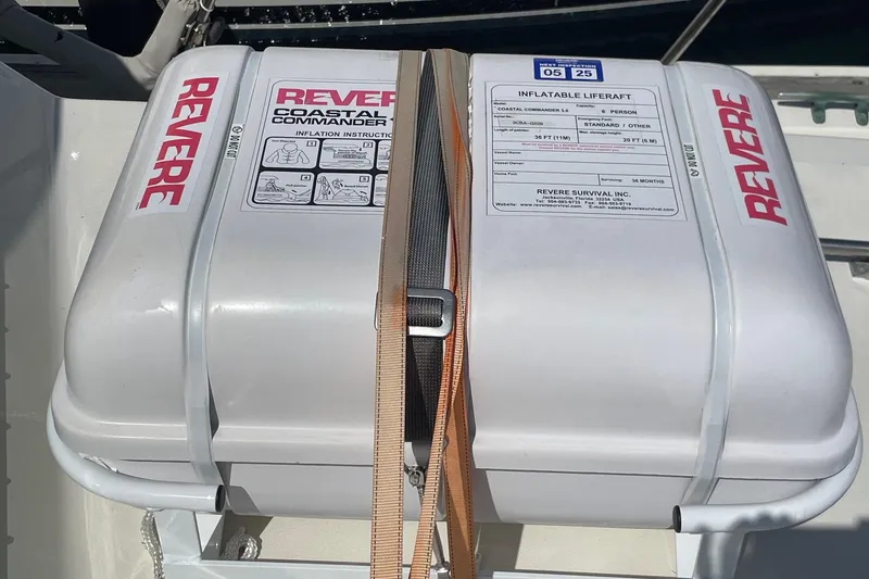 Inflatable liferaft on 1975 Uniflite Sport Fisher 42, secured with straps, labeled "Revere."
