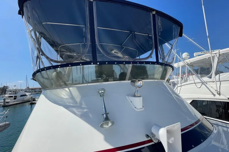 1975 Uniflite Sport Fisher 42 boat with blue canopy, docked in a marina.