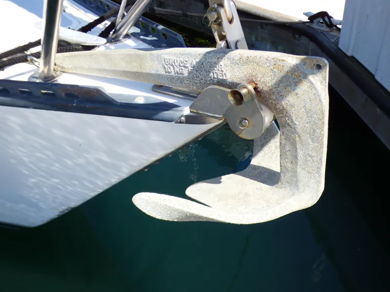 Anchor on 1982 Catalina 38 sailboat, secured at the bow, above clear water.