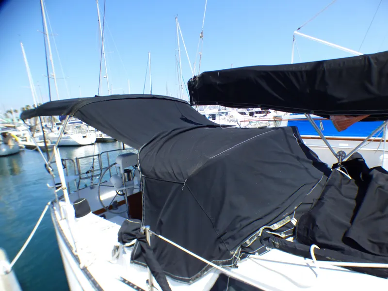 1982 Catalina 38 sailboat with black covers docked in a marina.