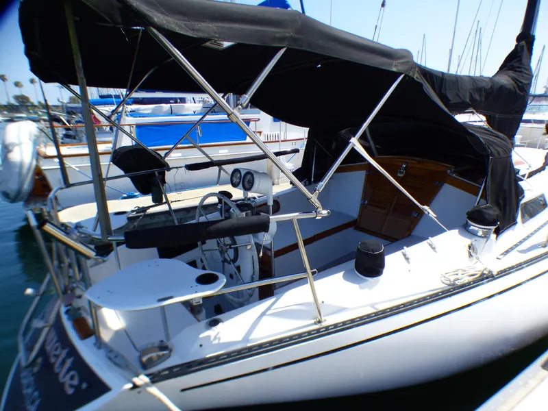 1982 Catalina 38 sailboat with black canopy docked at marina.