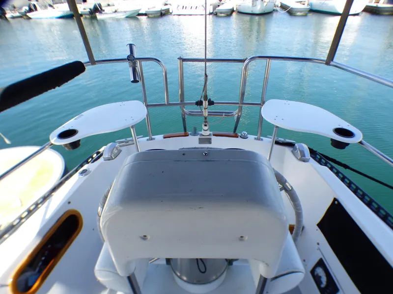 Cockpit view of a 1982 Catalina 38 sailboat, featuring helm and seating, docked in a marina.