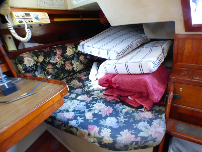 Interior of 1982 Catalina 38 sailboat with floral cushions and wooden cabinetry.