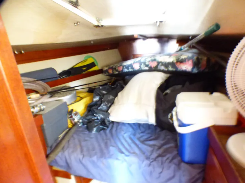 Cluttered cabin interior of a 1982 Catalina 38 sailboat with various items and bedding.