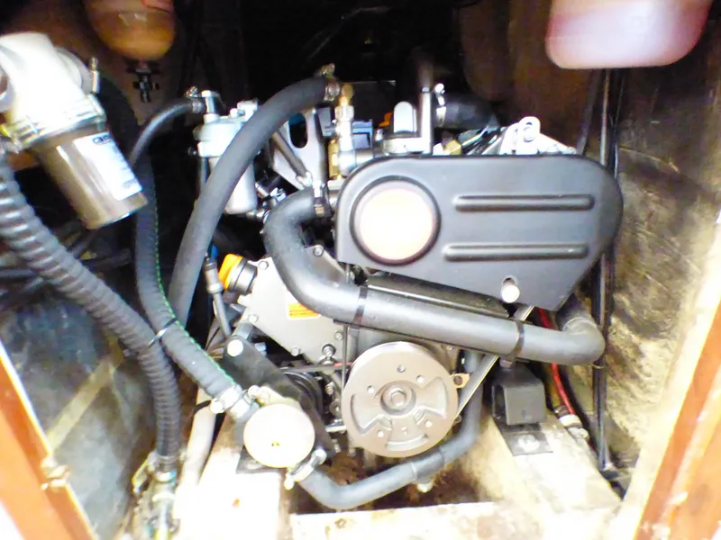 Engine compartment of a 1982 Catalina 38 sailboat, showcasing mechanical components and hoses.